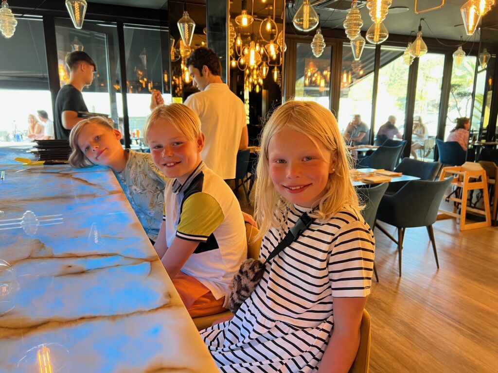 Her sitter ungene i baren på en restaurant og sjarmerer servitørene. 